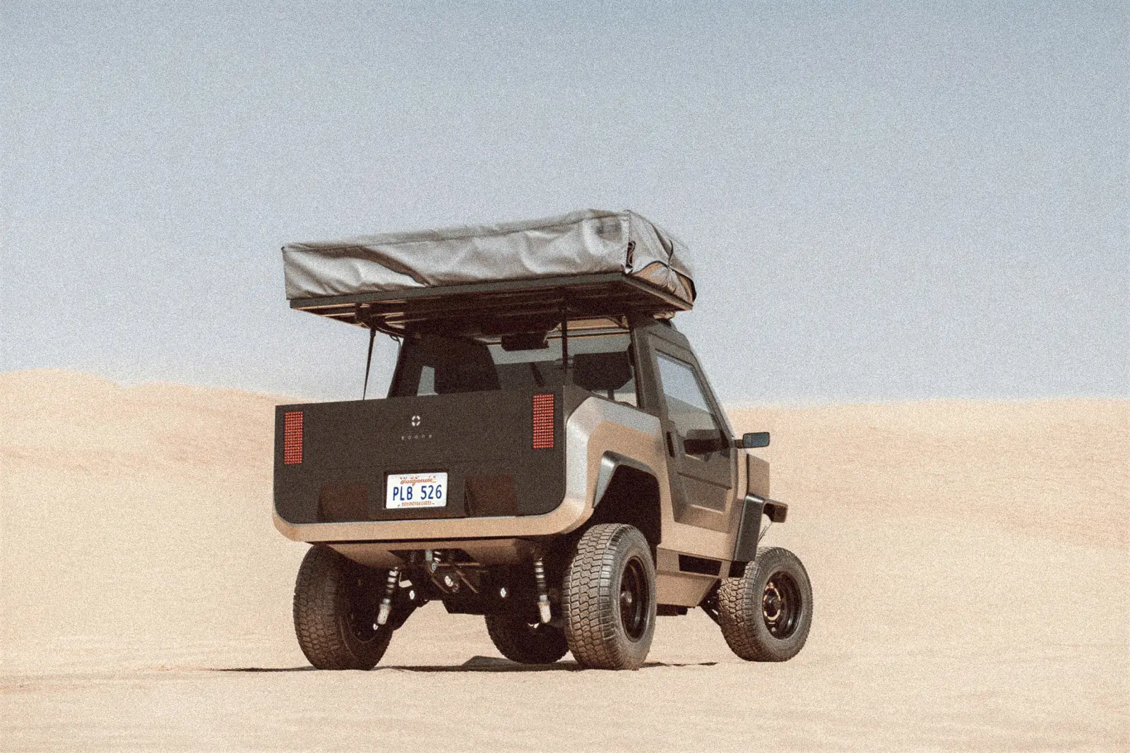 Overlander from the rear on sand dunes with a roof tent on the rack
